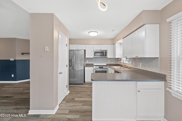 kitchen with backsplash, stainless steel appliances, sink, and white cabinets