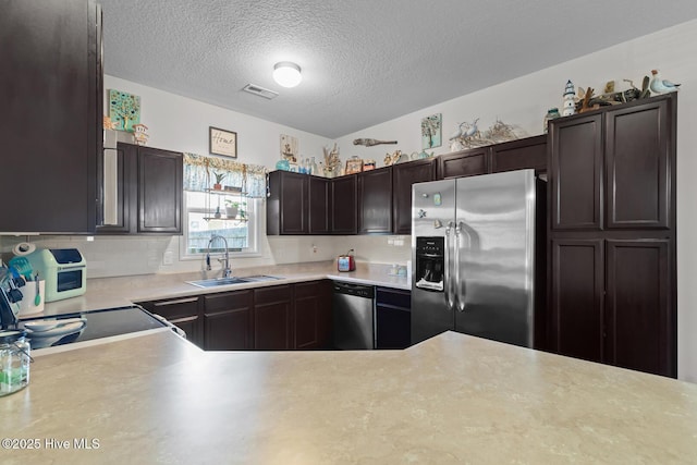 kitchen featuring sink, dark brown cabinets, a textured ceiling, appliances with stainless steel finishes, and decorative backsplash