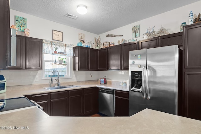 kitchen featuring dark brown cabinetry, appliances with stainless steel finishes, sink, and backsplash