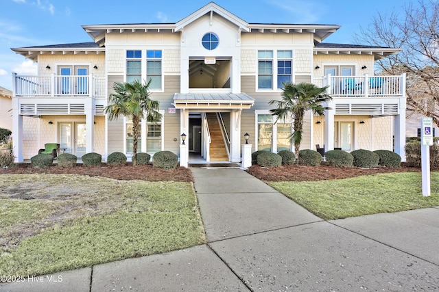 view of front of property featuring a balcony and a front lawn