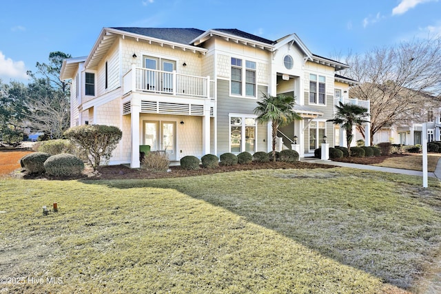 view of front of house with a balcony and a front lawn