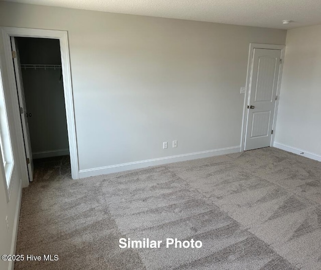 unfurnished room with light carpet and a textured ceiling