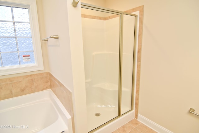 bathroom featuring tile patterned flooring and shower with separate bathtub