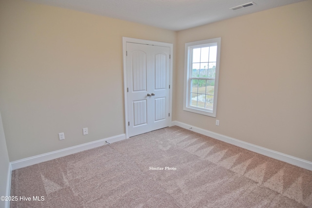 unfurnished room with light colored carpet