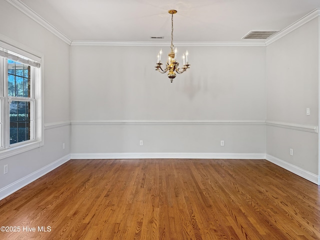 unfurnished room with hardwood / wood-style flooring, crown molding, and a notable chandelier