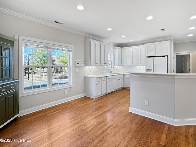 kitchen with white cabinetry, white appliances, ornamental molding, and light hardwood / wood-style flooring