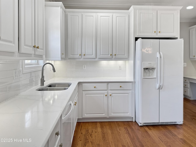 kitchen featuring white refrigerator with ice dispenser, sink, hardwood / wood-style floors, and white cabinets