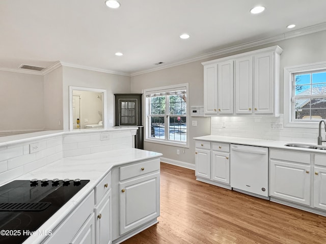 kitchen featuring dishwasher, sink, white cabinets, black electric stovetop, and light hardwood / wood-style floors