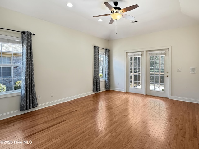 spare room with hardwood / wood-style floors, a healthy amount of sunlight, and ceiling fan