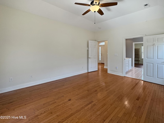 unfurnished bedroom featuring a raised ceiling and light wood-type flooring