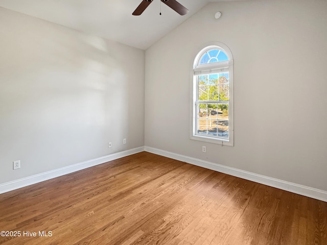 spare room featuring wood-type flooring, lofted ceiling, and ceiling fan