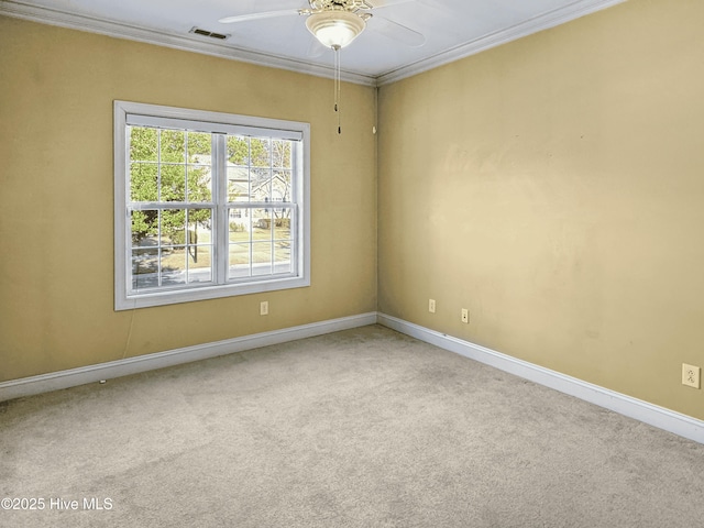 empty room with crown molding, ceiling fan, and carpet