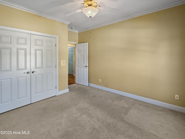 unfurnished bedroom featuring crown molding, a closet, ceiling fan, and light carpet