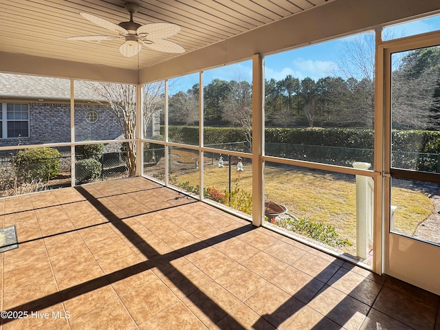 unfurnished sunroom featuring wood ceiling and ceiling fan