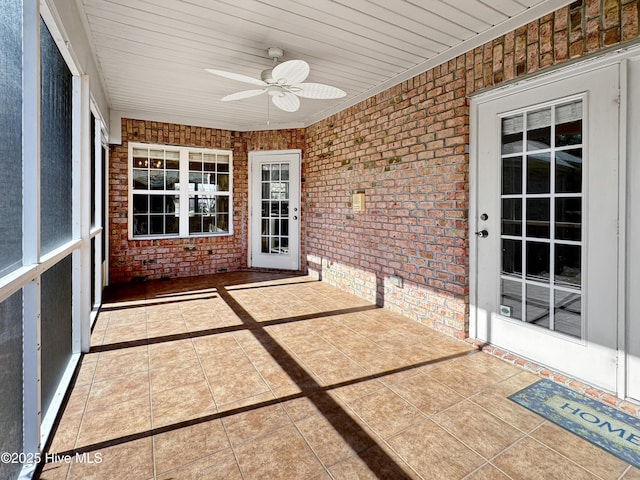 unfurnished sunroom featuring wood ceiling and ceiling fan