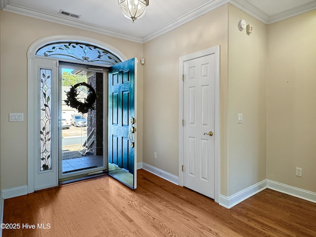 foyer entrance with wood-type flooring and ornamental molding