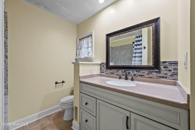 bathroom featuring tile patterned flooring, vanity, backsplash, and toilet