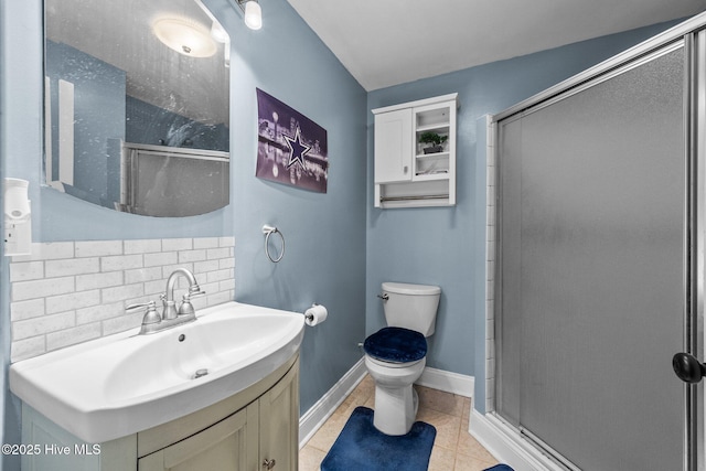 bathroom with tile patterned floors, toilet, a shower with shower door, vanity, and decorative backsplash