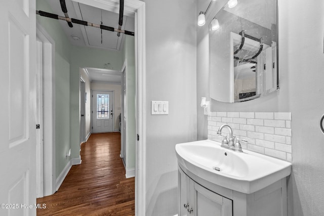 bathroom featuring vanity, hardwood / wood-style floors, and backsplash