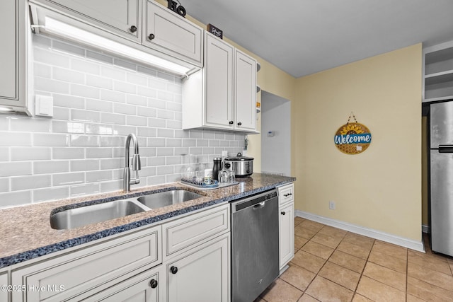 kitchen with appliances with stainless steel finishes, sink, and white cabinets