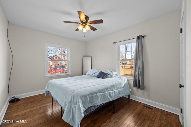 bedroom with dark hardwood / wood-style flooring and ceiling fan