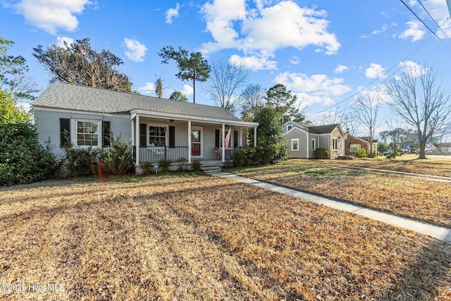 single story home featuring a porch and a front yard