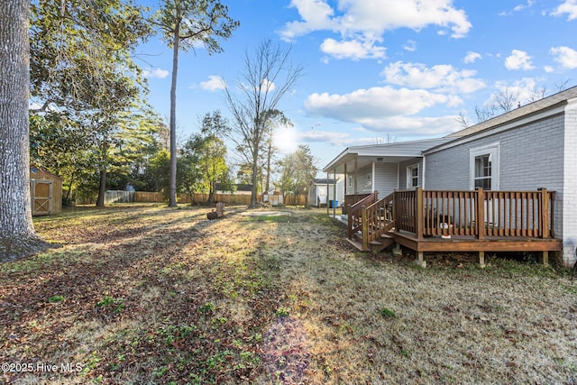 view of yard with a wooden deck and a storage unit