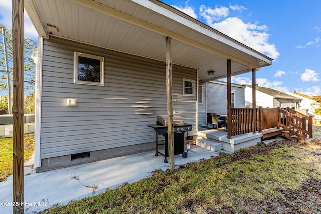 rear view of property featuring cooling unit, a wooden deck, and a patio