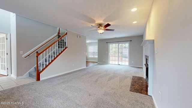 unfurnished living room featuring ceiling fan and light colored carpet