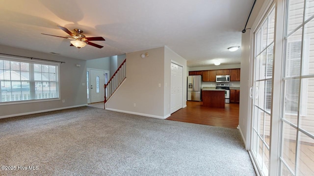 unfurnished living room featuring ceiling fan and carpet