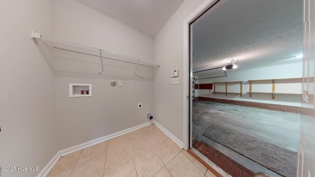 washroom featuring light tile patterned flooring, gas dryer hookup, washer hookup, hookup for an electric dryer, and a textured ceiling