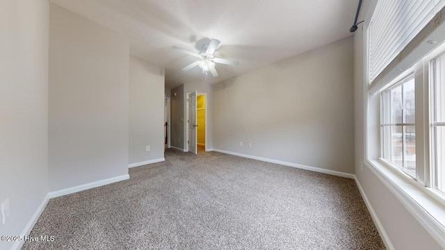 carpeted spare room featuring ceiling fan