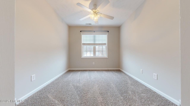 carpeted spare room featuring ceiling fan