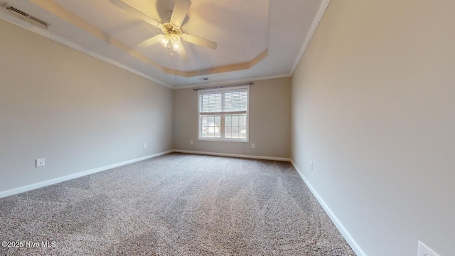 spare room featuring crown molding, a tray ceiling, ceiling fan, and carpet