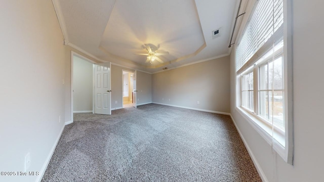 unfurnished bedroom with a raised ceiling, ornamental molding, carpet flooring, and ceiling fan