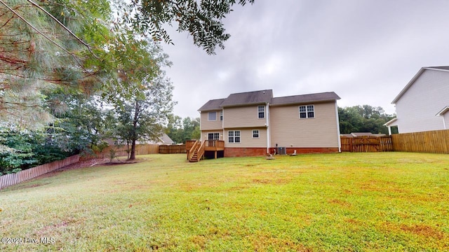 back of property with a lawn and a deck