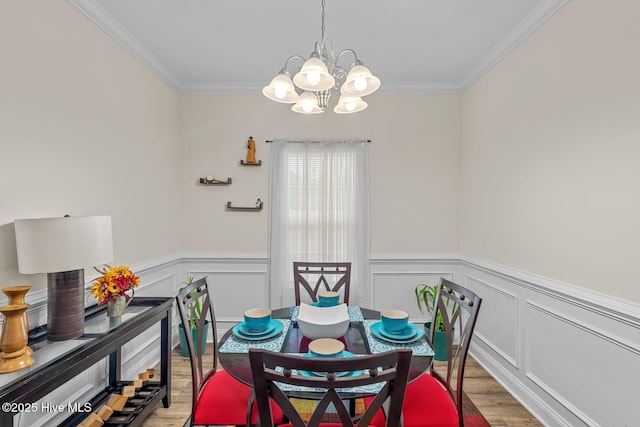 dining space featuring crown molding, an inviting chandelier, and light hardwood / wood-style flooring