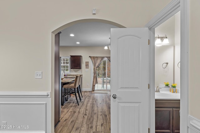 hall with light hardwood / wood-style floors and sink