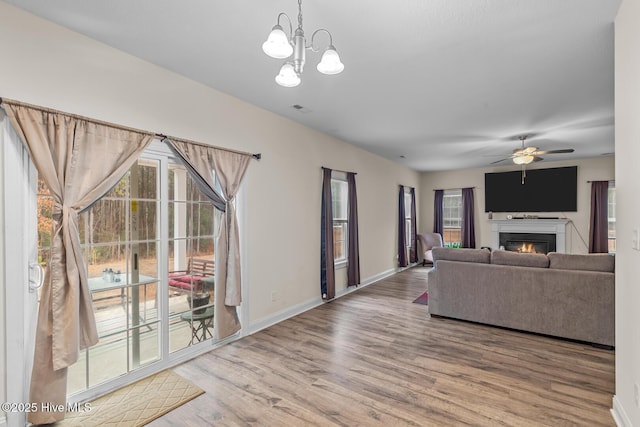 living room featuring hardwood / wood-style flooring, plenty of natural light, and ceiling fan with notable chandelier