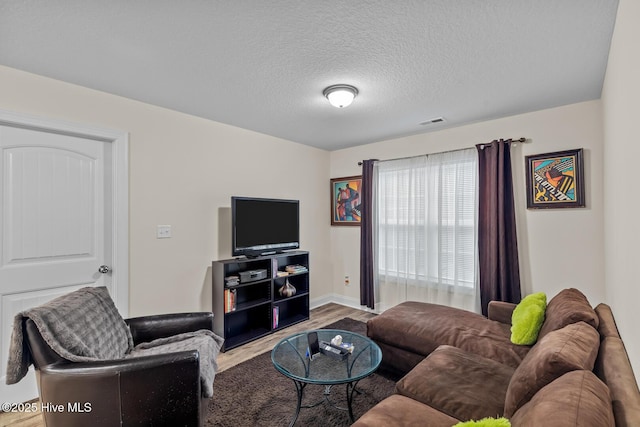 living room with a textured ceiling and light wood-type flooring