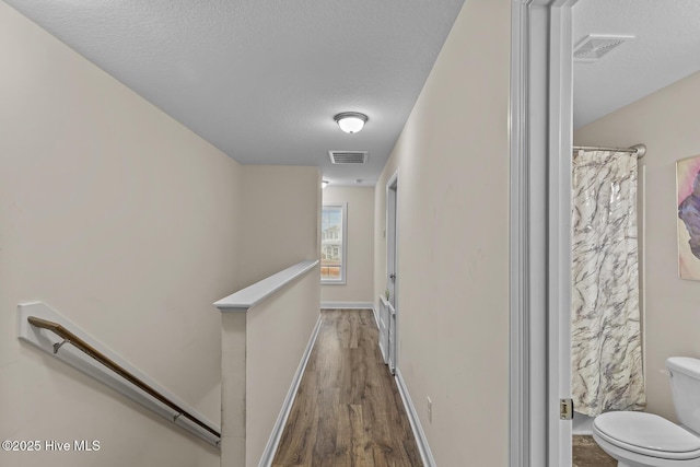 hall featuring hardwood / wood-style flooring and a textured ceiling