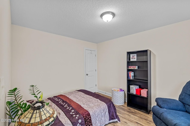 bedroom featuring light hardwood / wood-style flooring and a textured ceiling