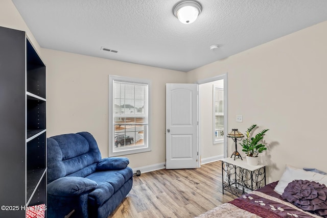 living area featuring wood-type flooring and a textured ceiling