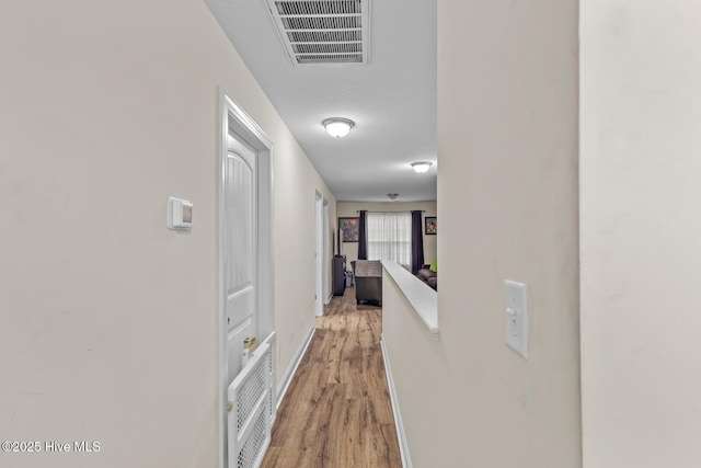 corridor with hardwood / wood-style flooring and a textured ceiling