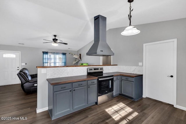 kitchen featuring stainless steel range with electric stovetop, wooden counters, hanging light fixtures, kitchen peninsula, and exhaust hood