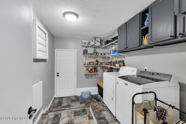 laundry area featuring washing machine and dryer, cabinets, and a textured ceiling