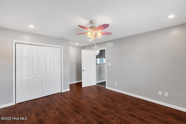 unfurnished bedroom featuring dark hardwood / wood-style flooring, a closet, and ceiling fan