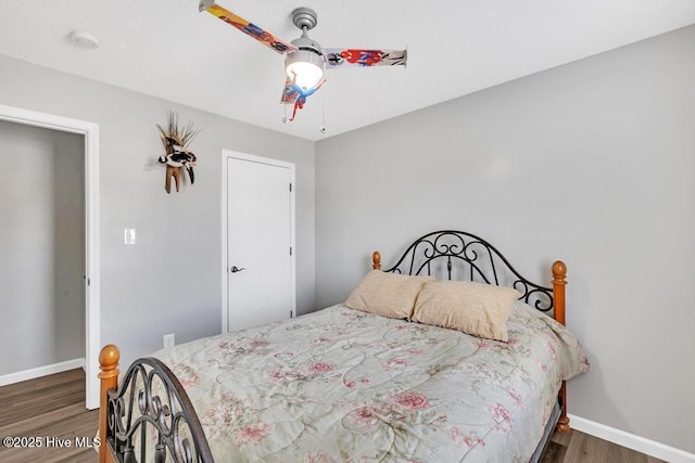 bedroom with dark hardwood / wood-style flooring and ceiling fan