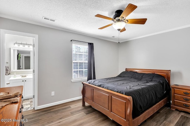 bedroom with hardwood / wood-style flooring, ornamental molding, a textured ceiling, and ensuite bathroom