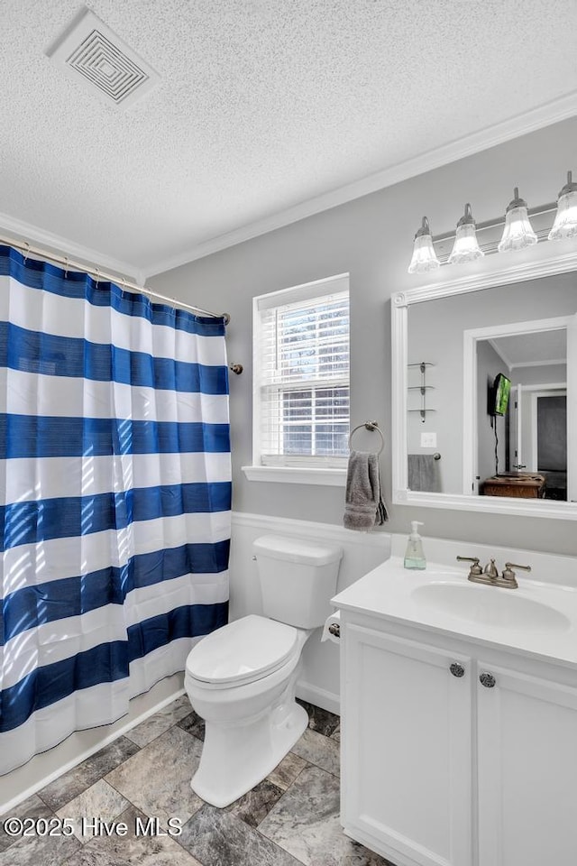 bathroom featuring vanity, crown molding, a textured ceiling, and toilet